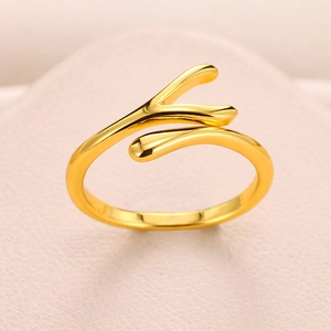 Detail shot of the polished gold intertwined droplet ring texture on pink leather