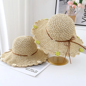 Women's wavy edge straw sun hats with floral crochet accents and ribbon detail