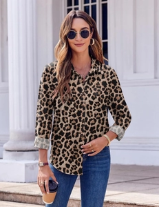 Outdoor shot of stylish leopard print long sleeve shirt paired with denim jeans