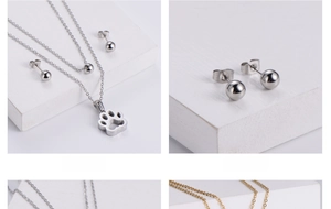 Detailed macro view of two-tone steel hollow paw pendant necklace and bead earrings