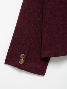 Close-up of deep red wool jacket cuffs with textured fabric and brown buttons