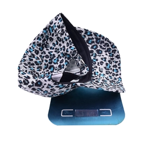 Blue and black leopard print baseball cap with metal buckle on an electronic scale