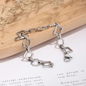 Close-up of geometric stainless steel chain with square and gear links on wooden tray