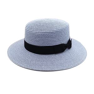 Detail of lavender boater hat with fine straw texture and a black bow ribbon