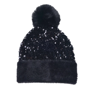 Close-up of black sequined knit beanie with a fluffy faux fur trim and large pompom detail
