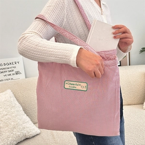 Detail of red checkered canvas tote bag with Cheerful Sozakka woven label and soft fabric