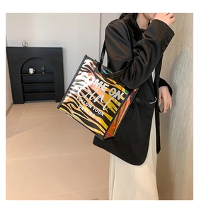 Holographic zebra print tote bag shown on a model in a minimalist indoor setting