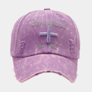 Close-up of distressed purple washed cotton baseball cap with Give Blood embroidery