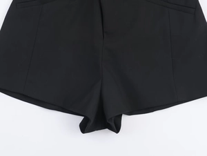 Dettaglio della tutina nera stile abito doppiopetto con tessuto twill e cuciture rifinite