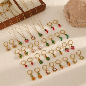 Christmas themed stainless steel jewelry set featuring colorful enamel pendants and gold hoops