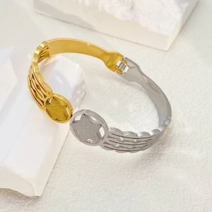 Macro detail of mixed-color steel bangle featuring star charms and wavy hollow patterns