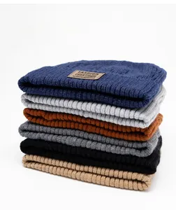 Detail showing thick ribbed texture and leather tags of various colored winter beanies