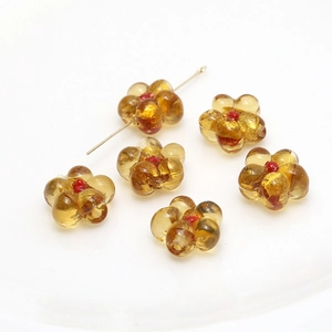 Macro shot of amber glass flower beads with red centers for DIY jewelry crafting