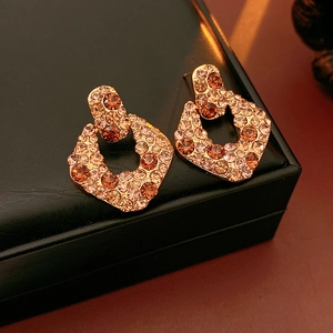 Gros plan de boucles d'oreilles vintage avec zircons champagne sur cuir noir