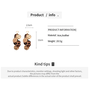 Detail view of round leopard print leather and gold iron fringe earrings with dimensions