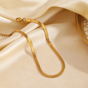 Minimalist gold snake chain anklet for beach fashion on champagne silk background