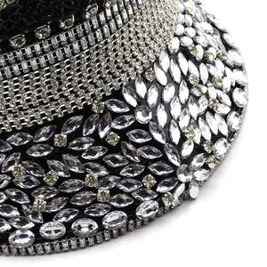 Macro shot of silver sequins and mixed-cut rhinestones on a luxury black fabric base
