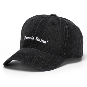 Detail of white Pamela Raina embroidery on washed black denim cotton baseball cap