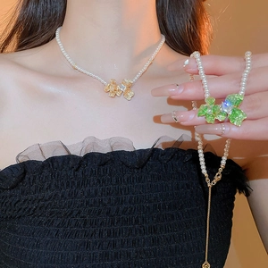 Elegant pearl necklace with crystal zircon flower pendants in gold and green colors