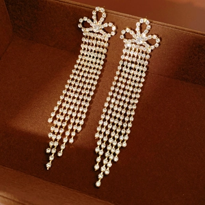 Dettaglio degli orecchini vintage dorati con nappe di strass su base in velluto scuro