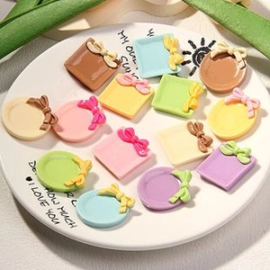 Macro view of assorted colorful resin miniature plates and gift box charms for DIY crafts