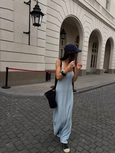 Light blue knitted maxi beach dress with wave texture on an outdoor street background