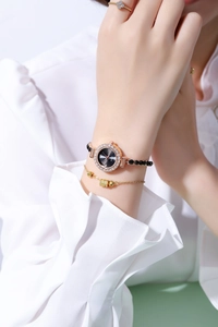 Detail of gold diamond-set watch and matching bracelets set on woman's wrist