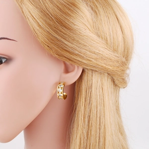 Gold C-shaped hoop earrings with inlaid heart-shaped cubic zirconia on a model