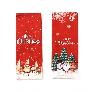 Two red Christmas wine bottle covers with Merry Christmas print and cartoon illustrations