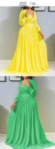 Macro detail of V-neckline and pleated waist belt on long-sleeved maxi dresses