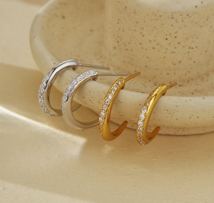 Close-up of gold and silver S925 sterling silver C-shaped earrings with micro-inlaid zircon