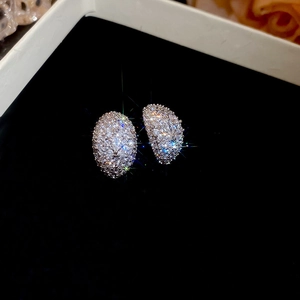 Detailed view of silver crescent earrings with micro-pave cubic zirconia on velvet
