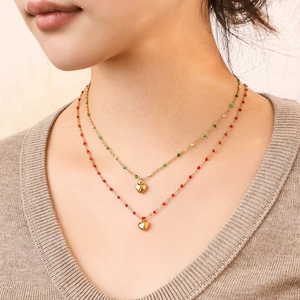 Collier double rang en acier doré avec pendentifs cœur et perles rouges et vertes