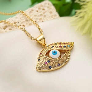 Bohemian gold plated necklace with colorful zircon evil eye pendant on white lace fabric