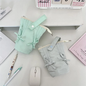 Close-up of pastel macaron pencil cases with decorative bows and portable wrist straps