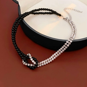 Detail of double-layer necklace with black beads and sparkling rhinestones on tray