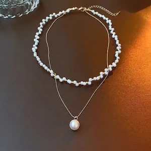 Double-layer vintage pearl necklace with golden cross chain and elegant white pendant
