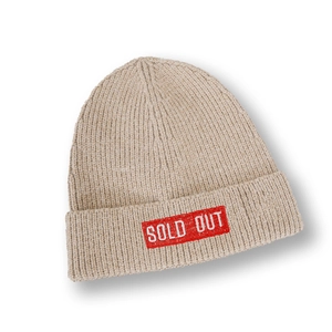 Vue détaillée du bonnet en maille beige avec écusson rouge et texte Sold Out sur le revers