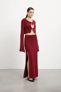 Détail de la maille du haut à lacets bordeaux et de la jupe longue à fente haute