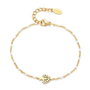 Macro detail of gold tree of life charm and white beads on stainless steel bracelet