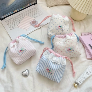 Détail de sacs de rangement en coton avec cordon, bordure dentelle et motifs étoiles
