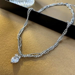 Elegant multi-layered silver necklace featuring a heart-shaped zircon pendant with bead chains