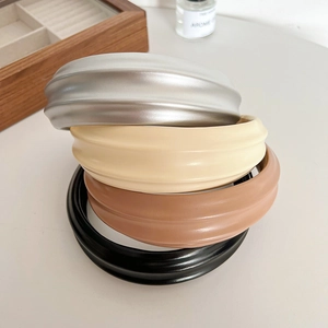 Cerchietti bombati larghi in ecopelle lucida argento, beige, marrone e nero sovrapposti