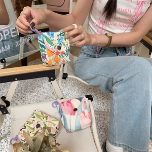 Detailed view of floral canvas mini storage pouches with metal snaps and purple lanyards