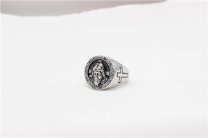 Close-up of vintage Jesus relief sculpture and side cross detail on men's steel ring