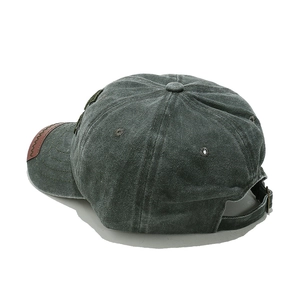 Detail view of washed grey baseball cap featuring leather brim and adjustable metal buckle