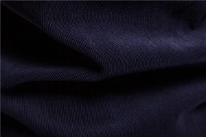 Macro detail of navy blue corduroy fabric showing the thick texture and soft ribbed finish