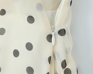 Detailansicht aus cremefarbenem Polka-Dot-Chiffon mit weißem unsichtbarem Reißverschluss