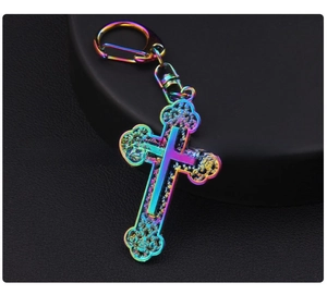 Detailed close-up of rainbow metal cross pendant with intricate hollow flower engraving