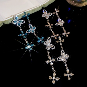 Macro shot of silver and rose gold butterfly tassel earrings with sparkling crystals
